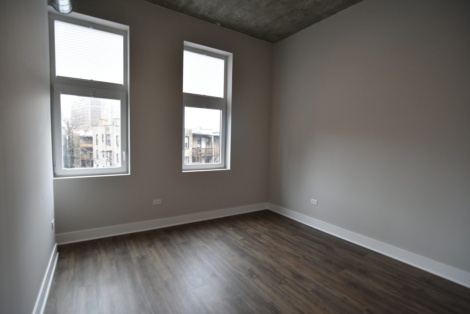 3833 North Broadway, Unit 313 Chicago, IL 60613 - Photo 4 of 8 an empty room with wooden floor and windows