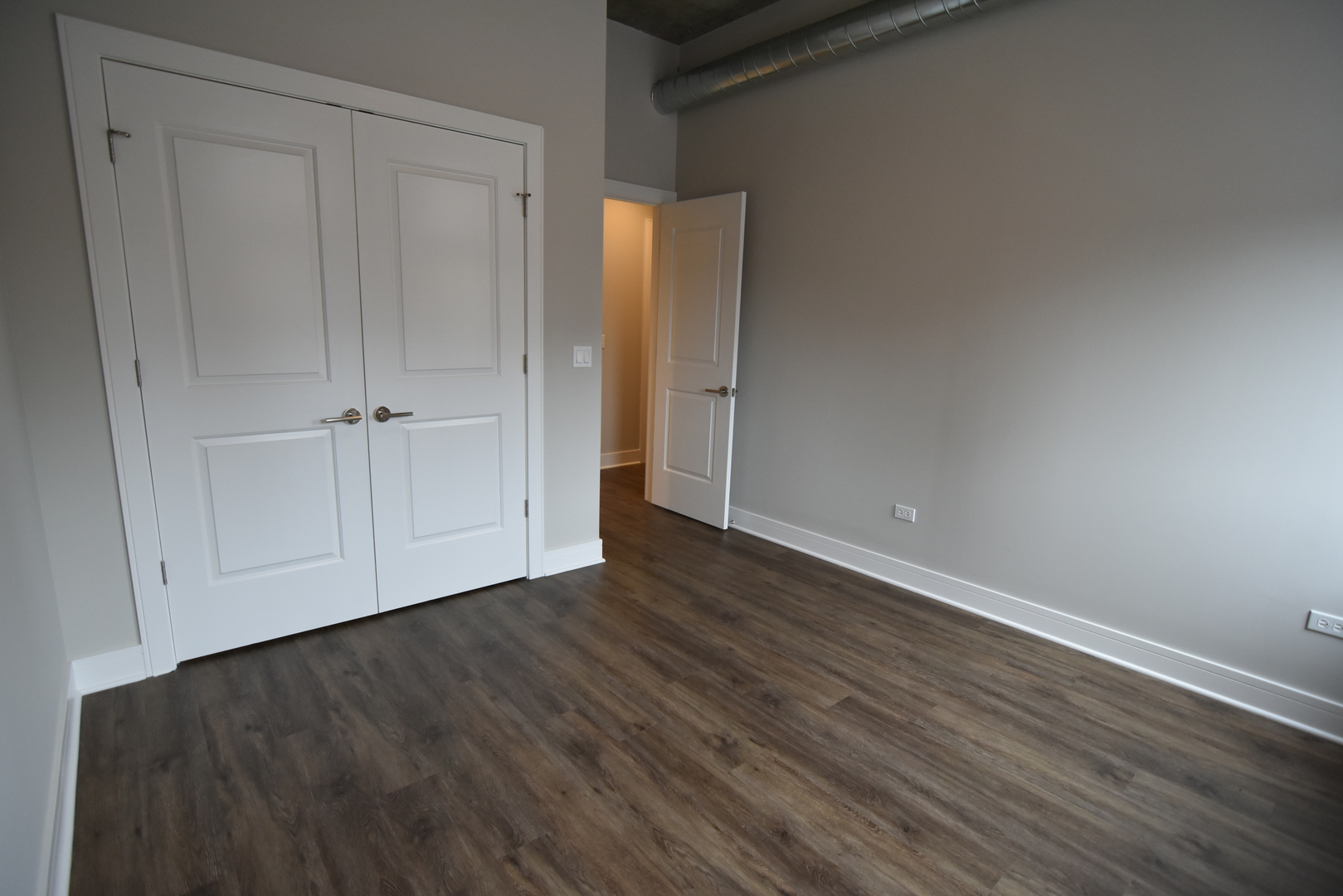 3833 North Broadway, Unit 313 Chicago, IL 60613 - Photo 6 of 8 a view of an empty room with closet and wooden floor