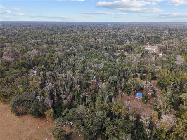 an aerial view of house with yard and mountain view in back