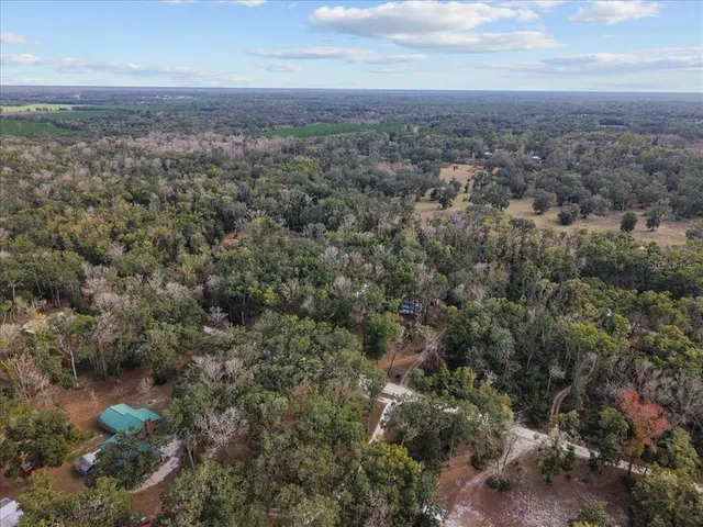 an aerial view of house with yard and mountain view in back