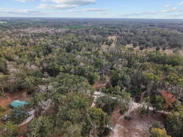 an aerial view of house with yard and mountain view in back