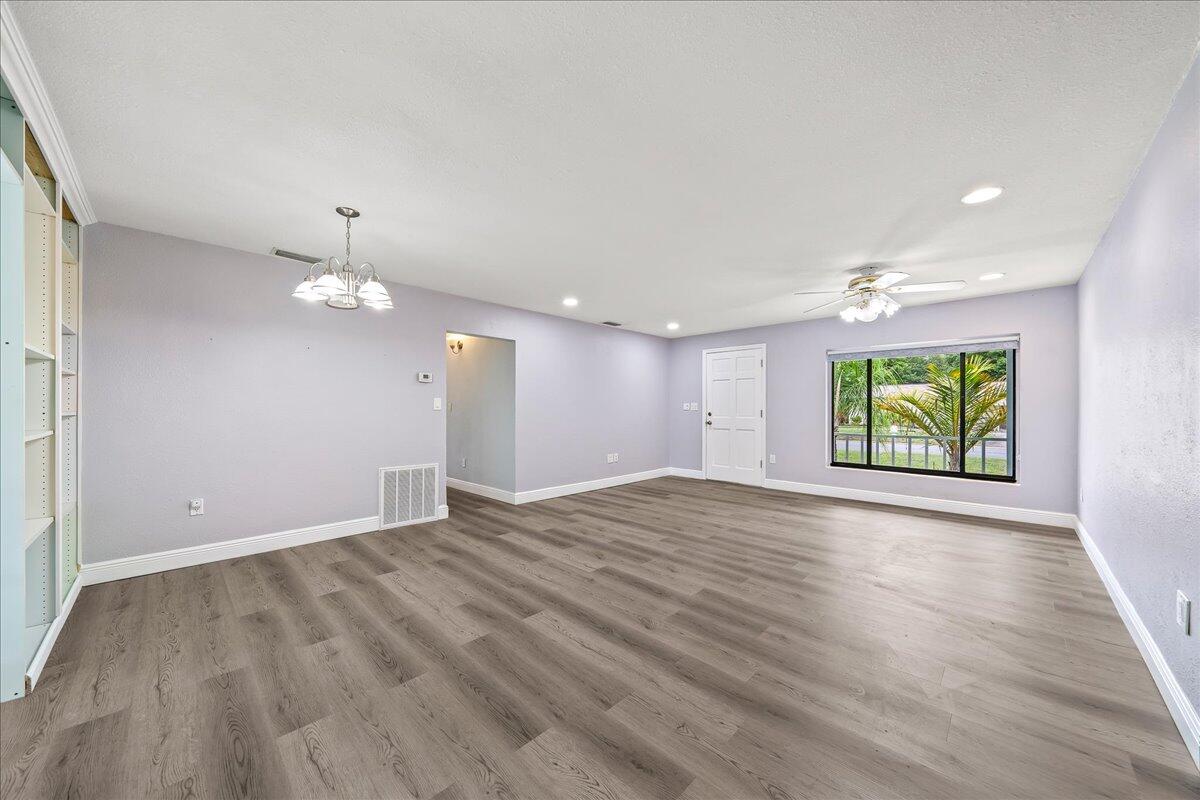 124 Monaco Road Melbourne, FL 32904 - Photo 12 of 24 an empty room with wooden floor and windows