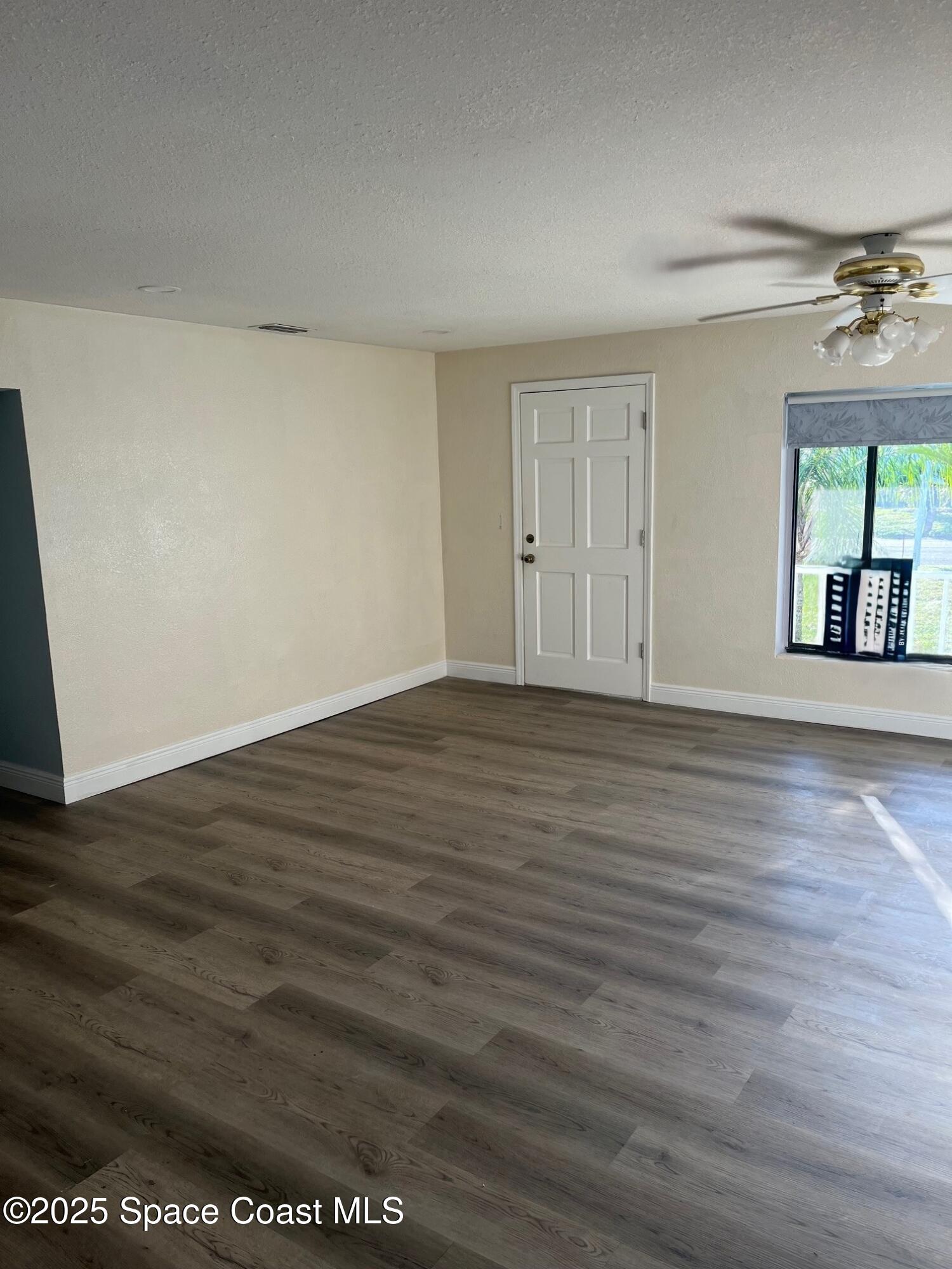124 Monaco Road Melbourne, FL 32904 - Photo 7 of 24 a view of an empty room with wooden floor and a window