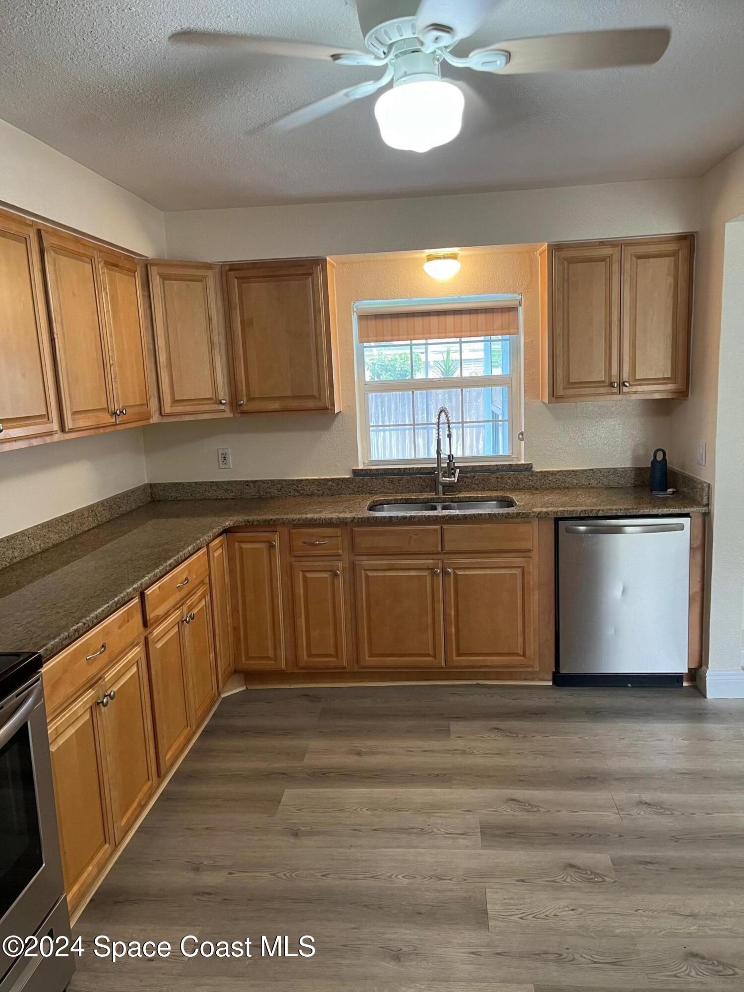 124 Monaco Road Melbourne, FL 32904 - Photo 10 of 24 a kitchen with stainless steel appliances granite countertop a stove a sink and a microwave