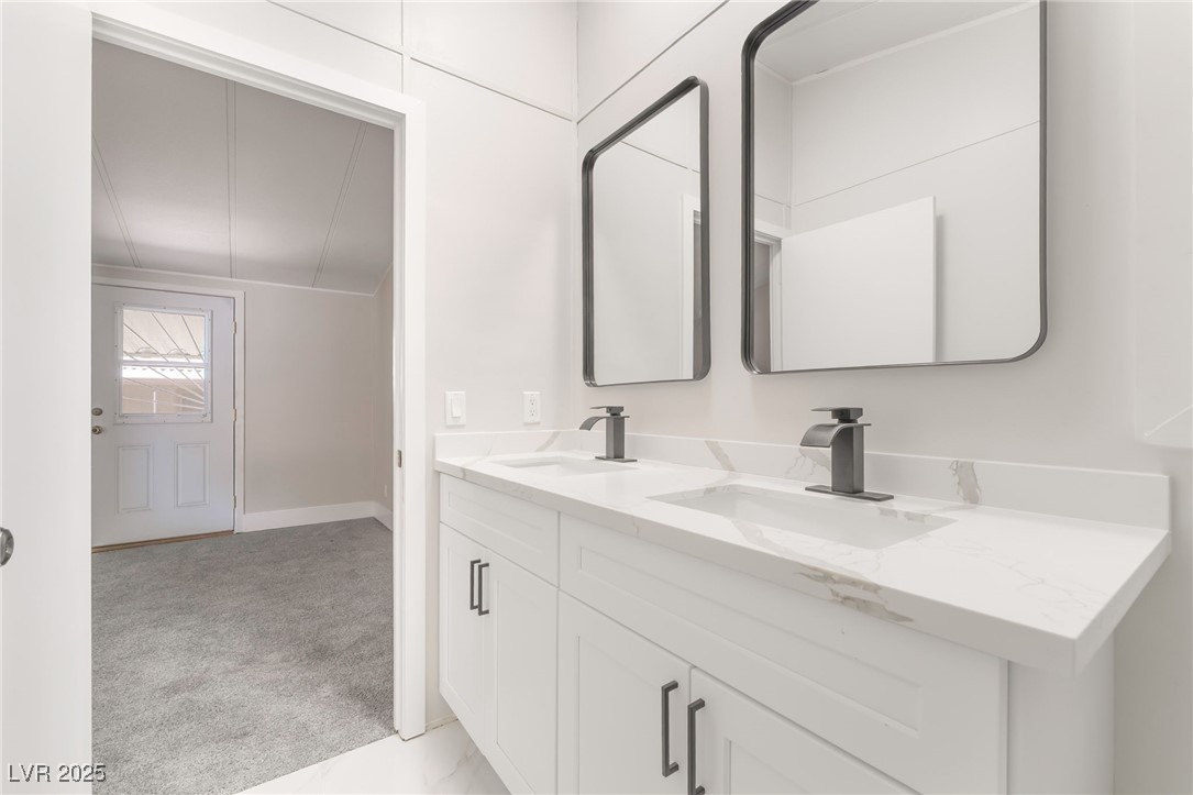 5552 Aldama Road Las Vegas, NV 89122 - Photo 19 of 35 Bathroom featuring double vanity and baseboards