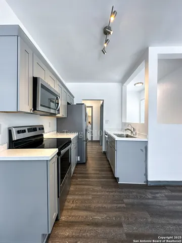 a large kitchen with stainless steel appliances granite countertop a stove and a sink