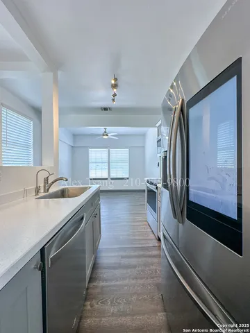 a view of a kitchen with a sink and refrigerator