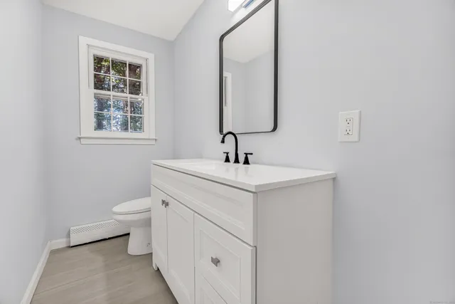a bathroom with a toilet sink and mirror