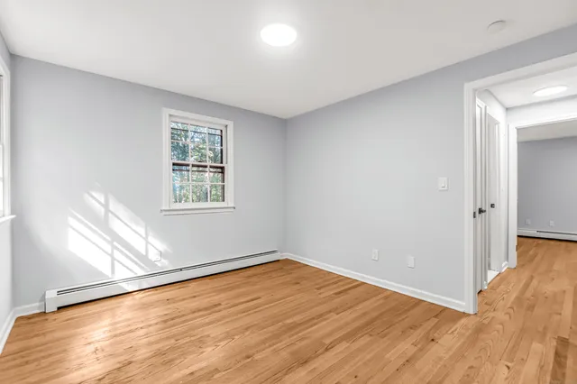 wooden floor in an empty room with a window