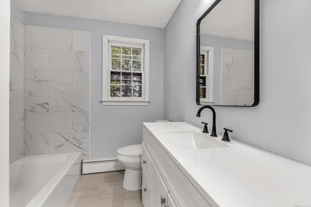 a bathroom with a sink toilet vanity and bathtub