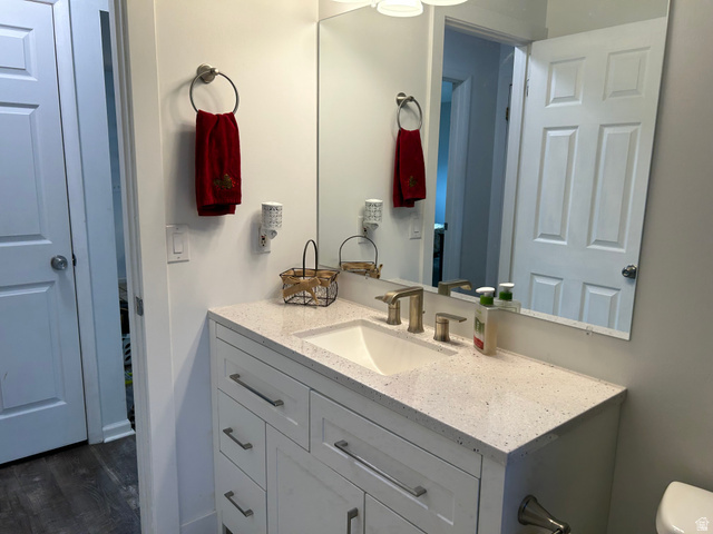 7659 State Street Midvale, UT 84047 - Photo 15 of 33 Half bathroom with vanity and dark wood-type flooring