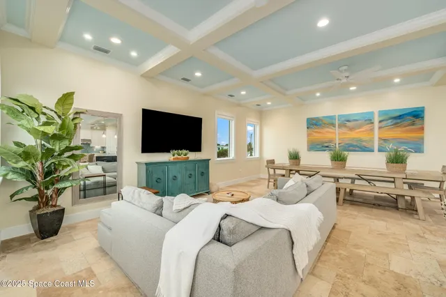 a living room with furniture a flat screen tv and a chandelier