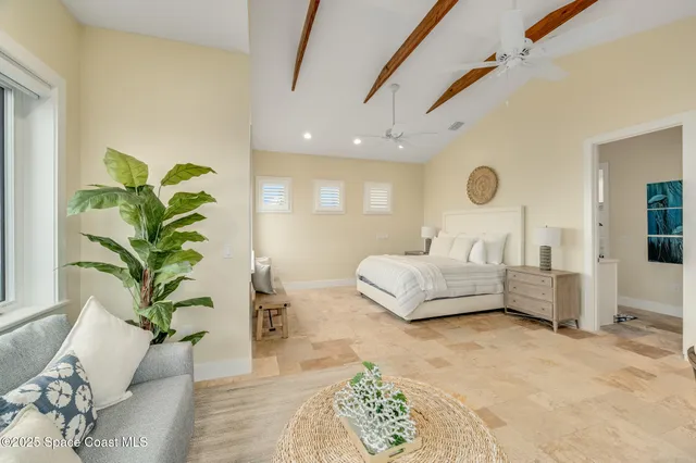 a bedroom with furniture a flat screen tv and a large window