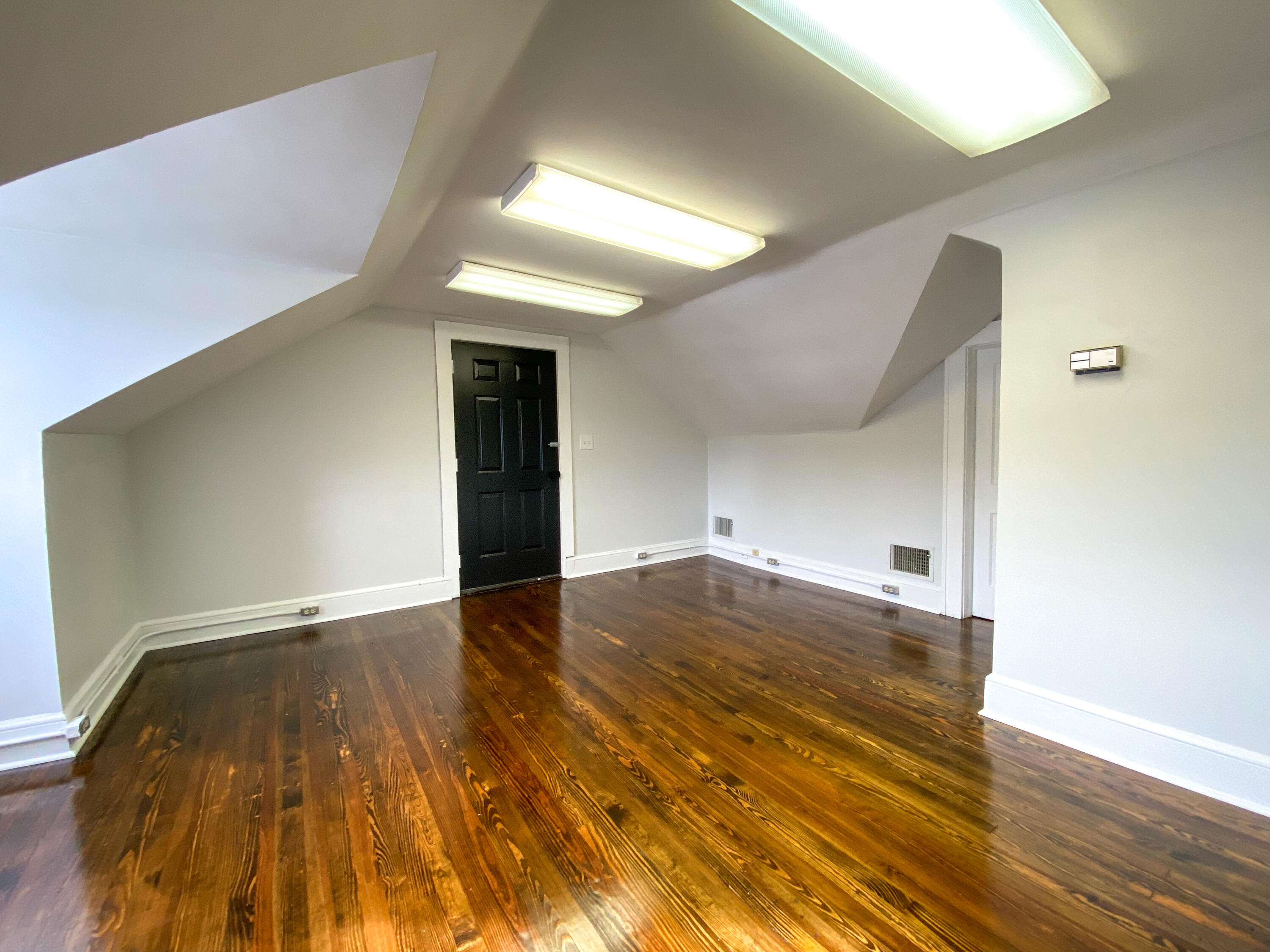 a view of empty room with wooden floor