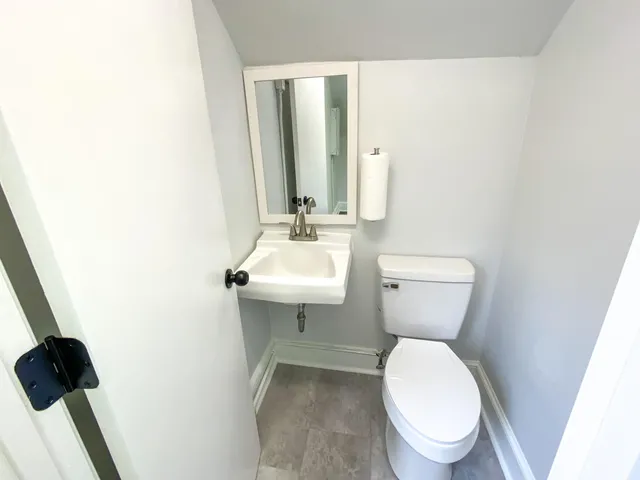 a bathroom with a toilet a sink and mirror