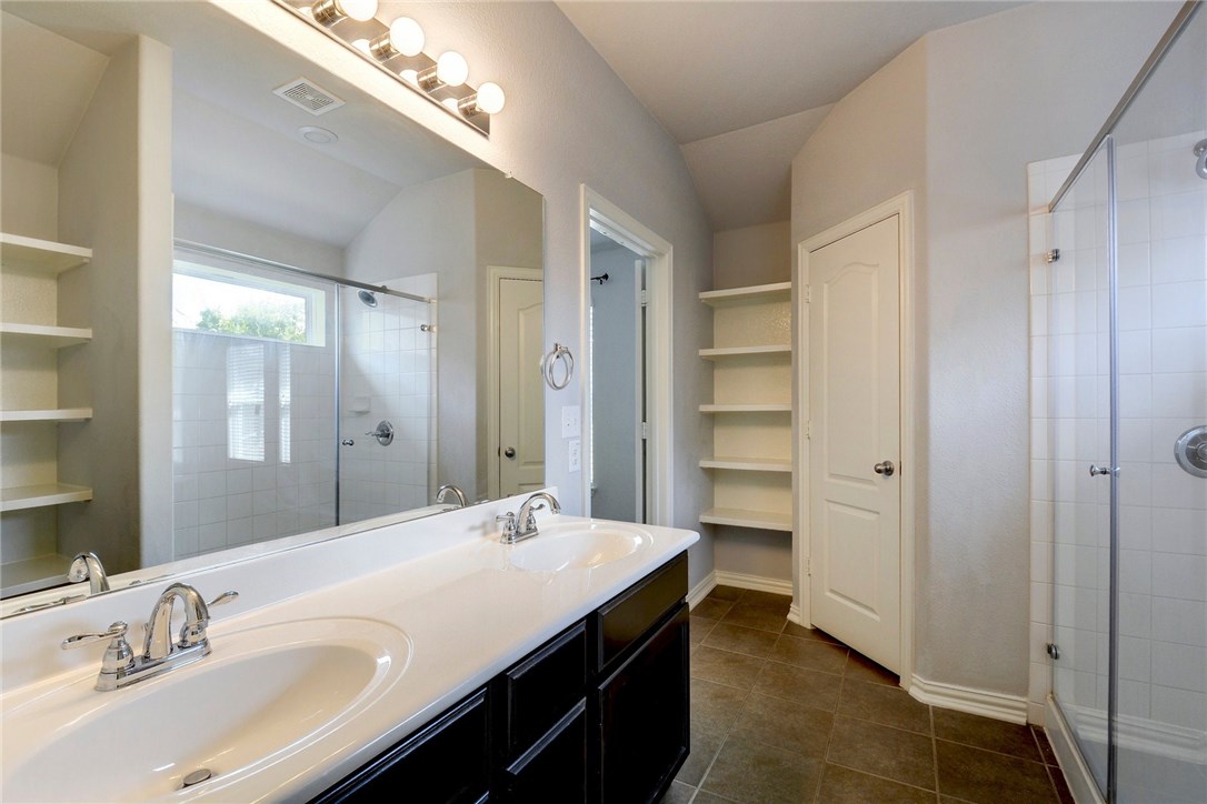 3621 Rams Horn Way Round Rock, TX 78665 - Photo 17 of 24 a bathroom with a double vanity sink a mirror and a shower