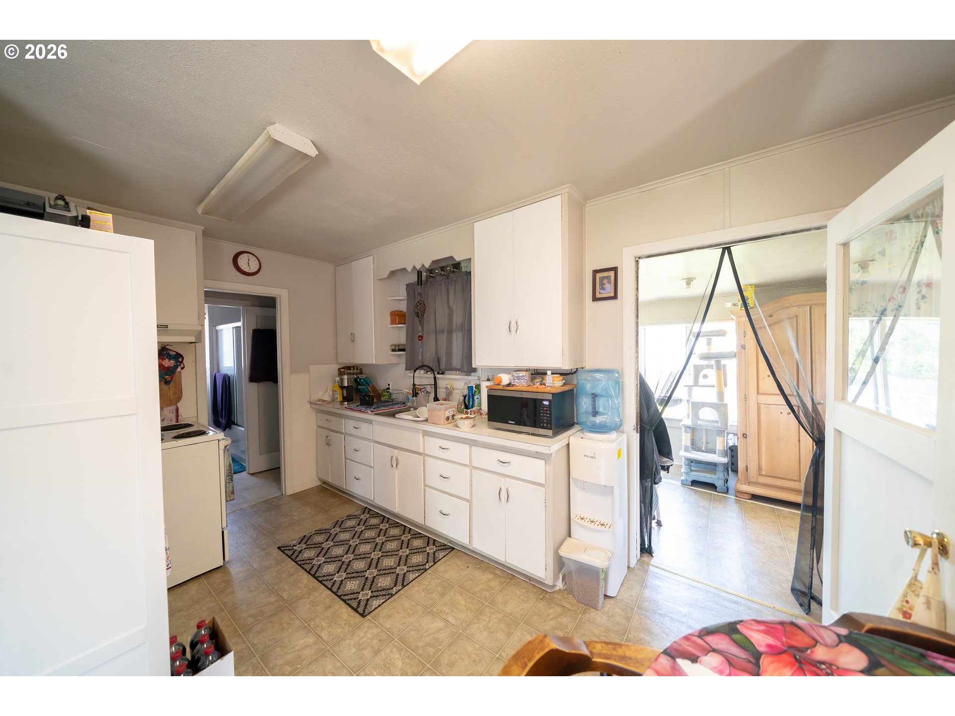 1450 Southwest 9th Street Dallas, OR 97338 - Photo 4 of 15 a kitchen with stainless steel appliances kitchen island granite countertop a refrigerator a sink dishwasher and white cabinets with wooden floor