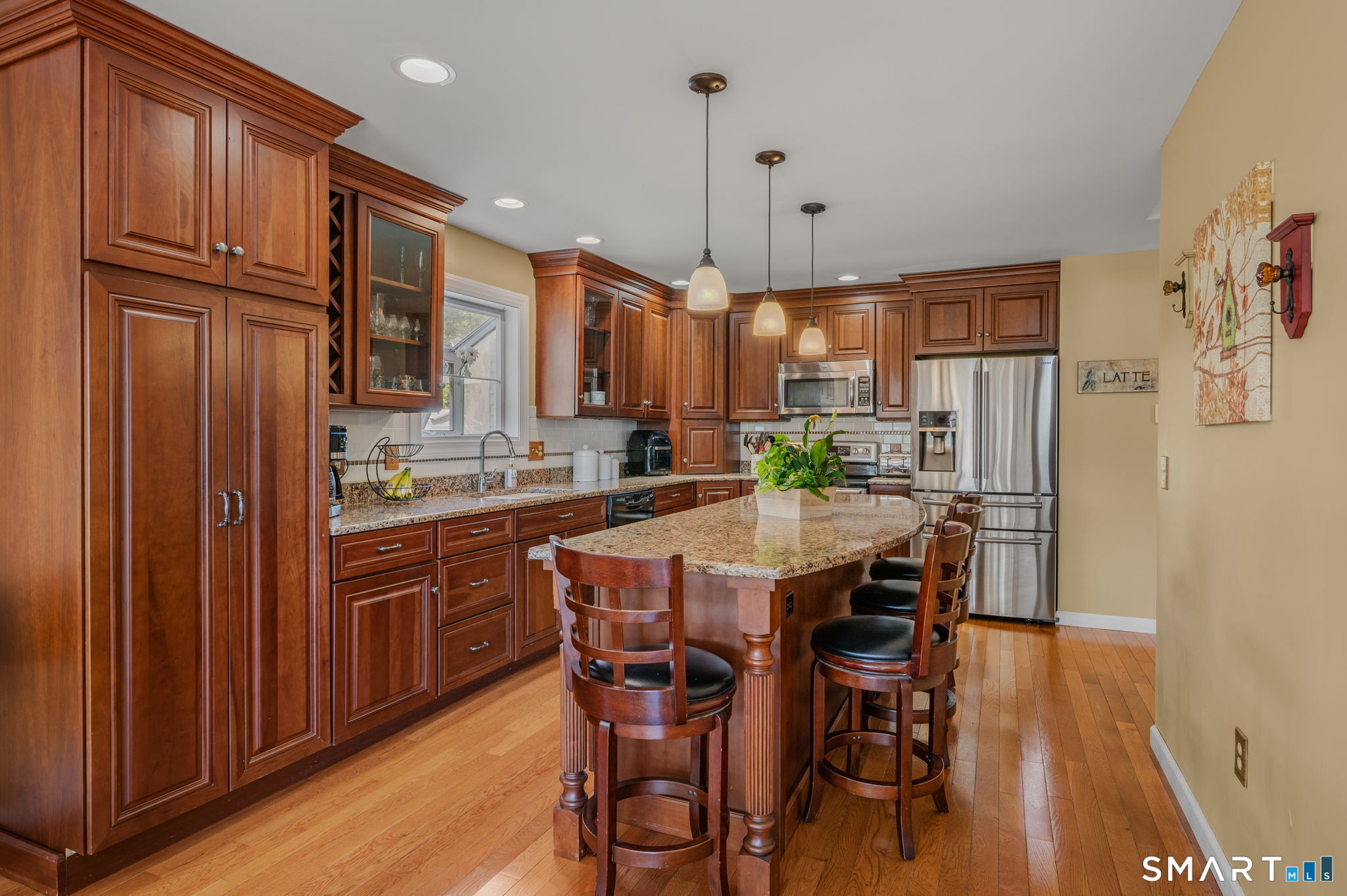 212 R Shore Road Waterford, CT 06385 - Photo 14 of 28 a kitchen with stainless steel appliances granite countertop a refrigerator a stove a sink dishwasher and a dining table with wooden floor