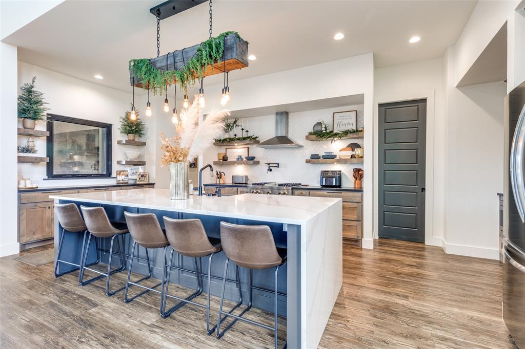 2687 North Trinity Street Decatur, TX 76234 - Photo 12 of 33 a kitchen with granite countertop a table chairs stove a refrigerator and cabinets