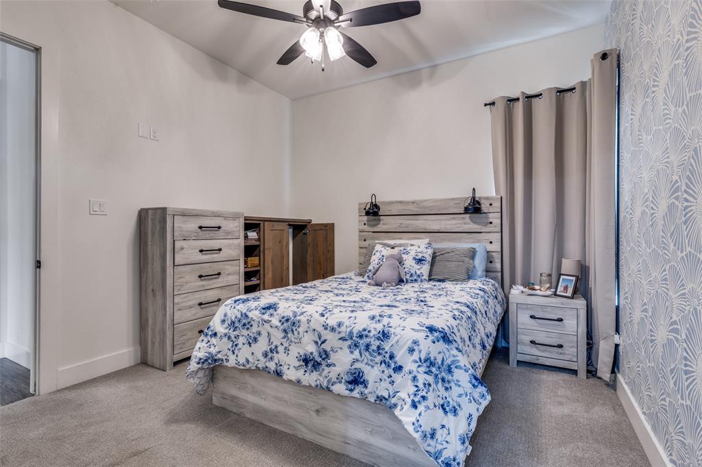 2687 North Trinity Street Decatur, TX 76234 - Photo 25 of 33 a bedroom with a bed and a chandelier