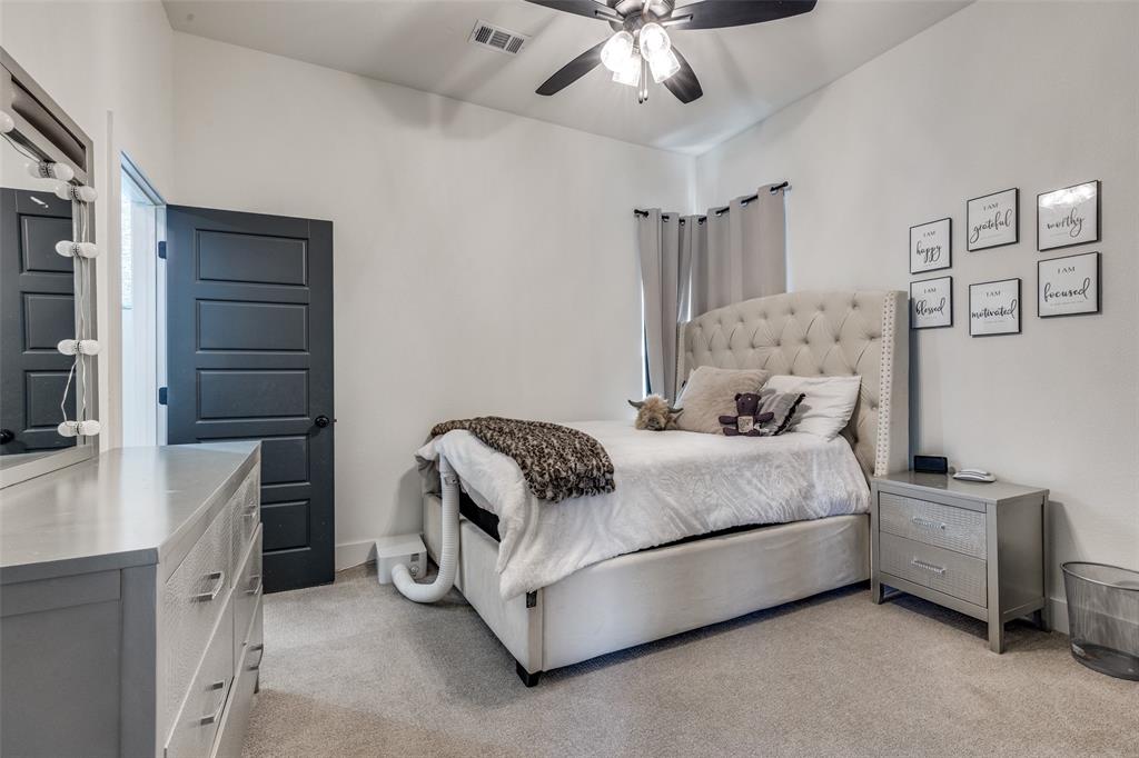 2687 North Trinity Street Decatur, TX 76234 - Photo 26 of 33 a bedroom with a bed and a chandelier