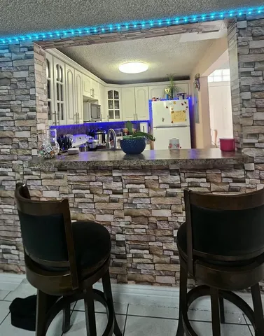 a kitchen with a stove a cabinets and chairs