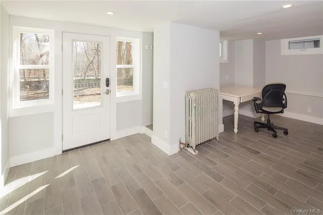 a view of a workspace with wooden floor and a window