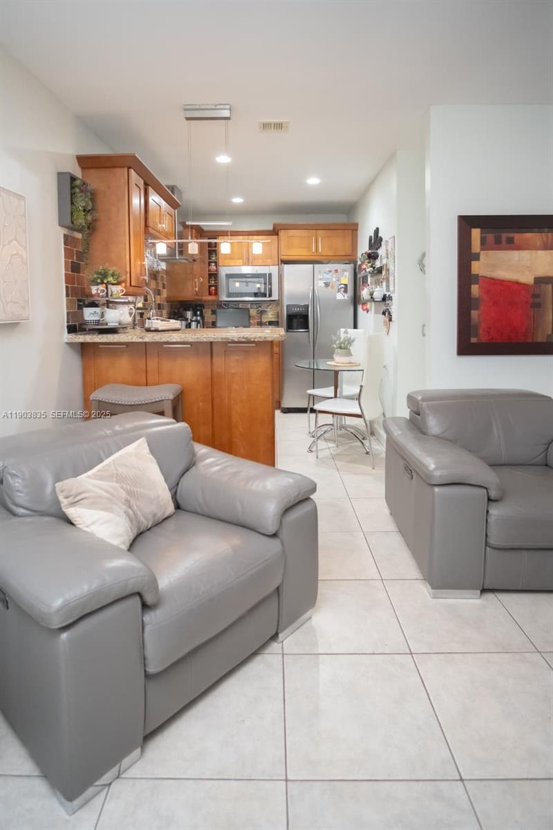 15076 Southwest 63rd Terrace Miami, FL 33193 - Photo 29 of 40 a living room with furniture and a kitchen view