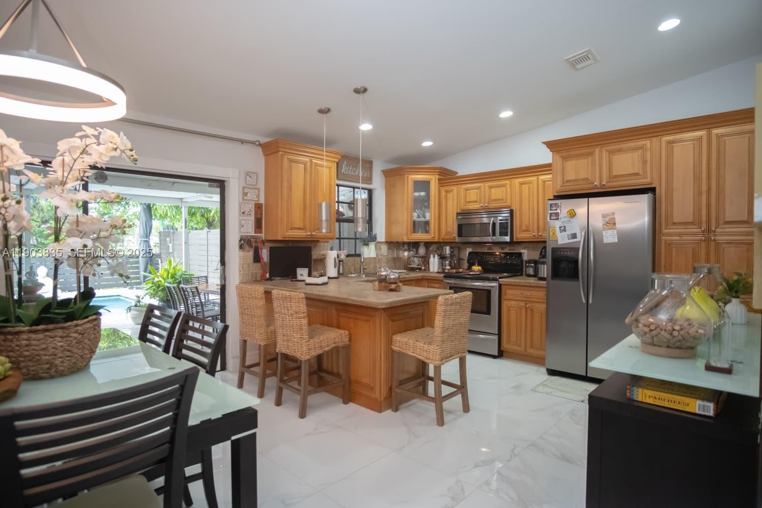 15076 Southwest 63rd Terrace Miami, FL 33193 - Photo 8 of 40 a kitchen with a refrigerator and a stove top oven