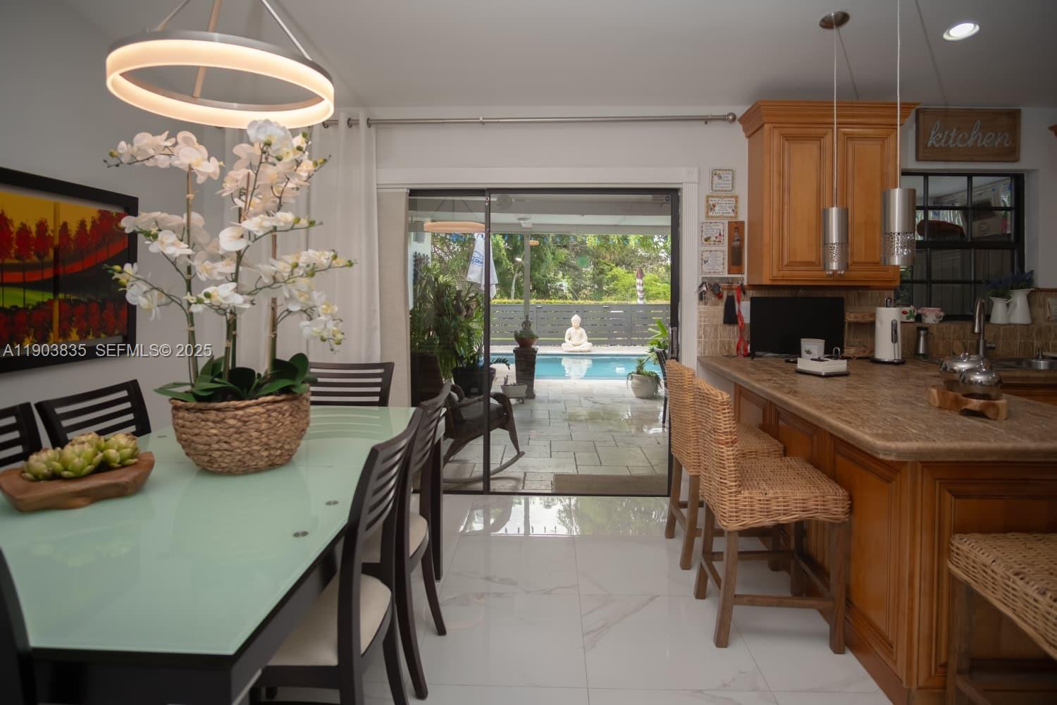 15076 Southwest 63rd Terrace Miami, FL 33193 - Photo 10 of 40 a view of a dining room with furniture a chandelier and wooden floor