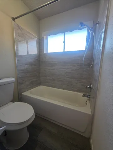 a bathroom with a toilet and a bath tub