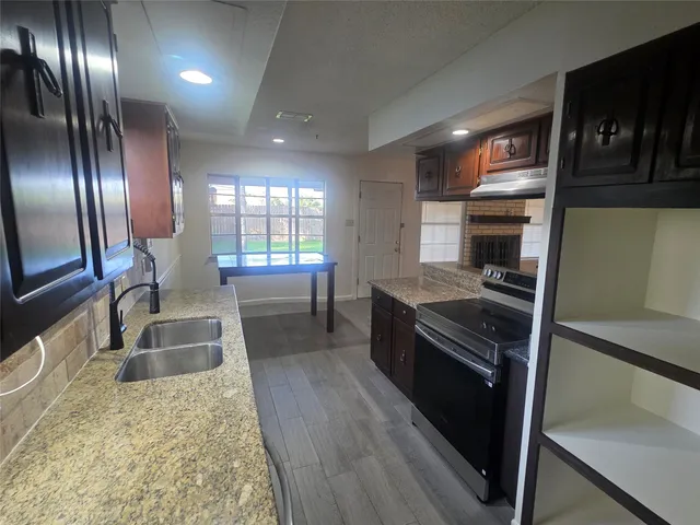 a kitchen with granite countertop stainless steel appliances and wooden cabinets