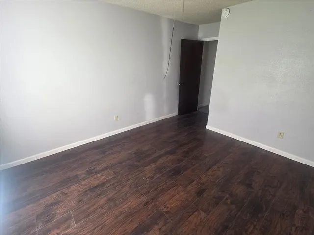 an empty room with wooden floor and closet