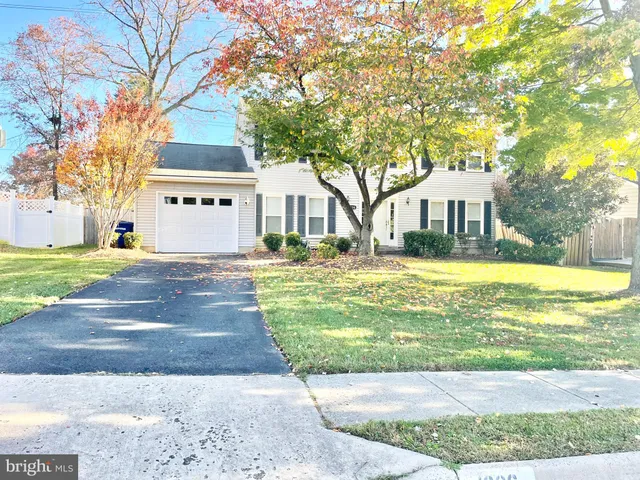 a front view of a house with a garden and trees