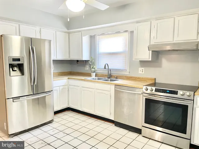 a kitchen with white cabinets appliances and sink