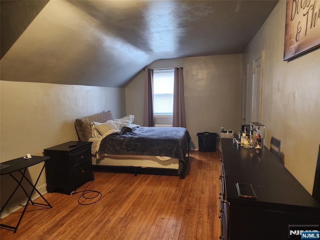 490 Beverly Road, Unit B6 Teaneck, NJ 07666 - Photo 14 of 17 a bedroom with a bed and wooden floor