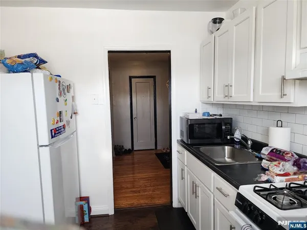 a kitchen with a stove and a wooden floor