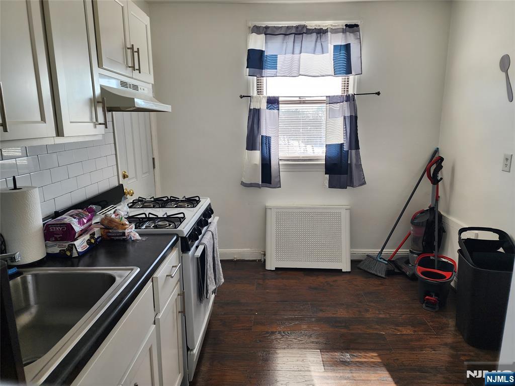 490 Beverly Road, Unit B6 Teaneck, NJ 07666 - Photo 8 of 17 a kitchen with a stove and a wooden floor