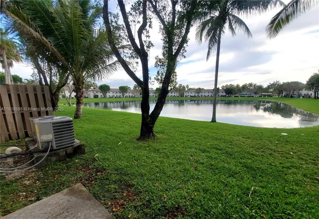 a view of a lake with a big yard and palm trees