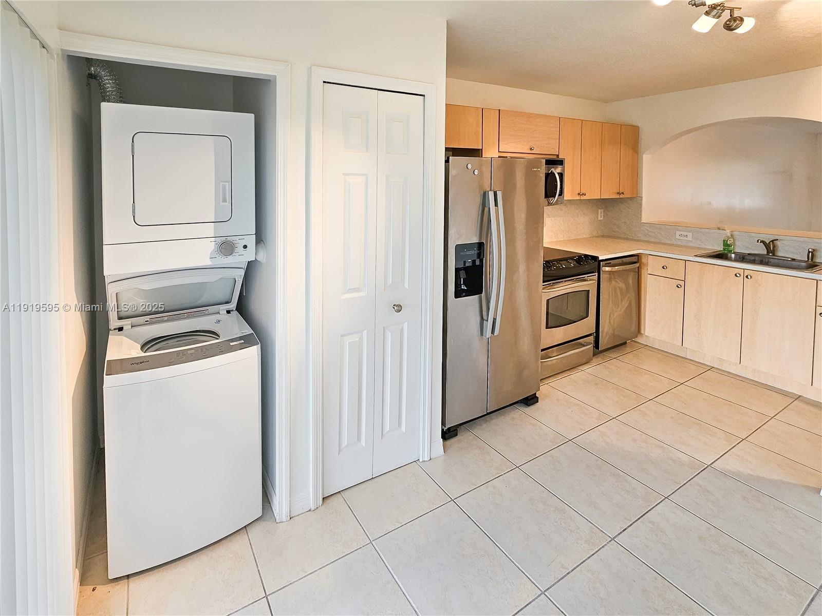 2651 Southeast 12th Road, Unit 105 Homestead, FL 33035 - Photo 3 of 24 a kitchen with a refrigerator sink and cabinets
