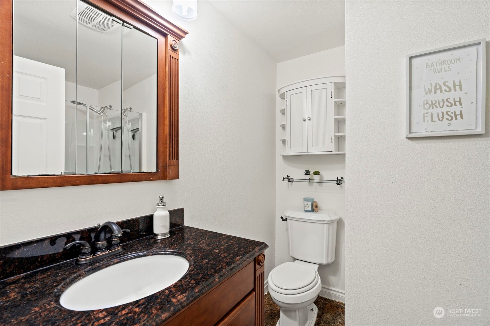 10033 Northeast 204th Street Bothell, WA 98011 - Photo 18 of 26 a bathroom with a granite countertop sink toilet a mirror and shower