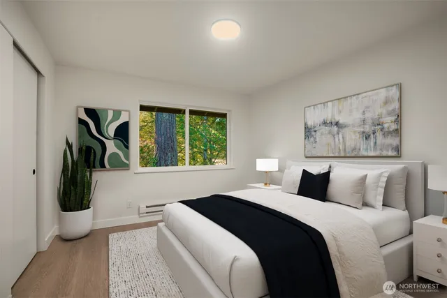 a bedroom with a large bed and a painting on the wall