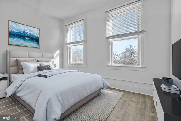 a bedroom with bed painting on the wall and window