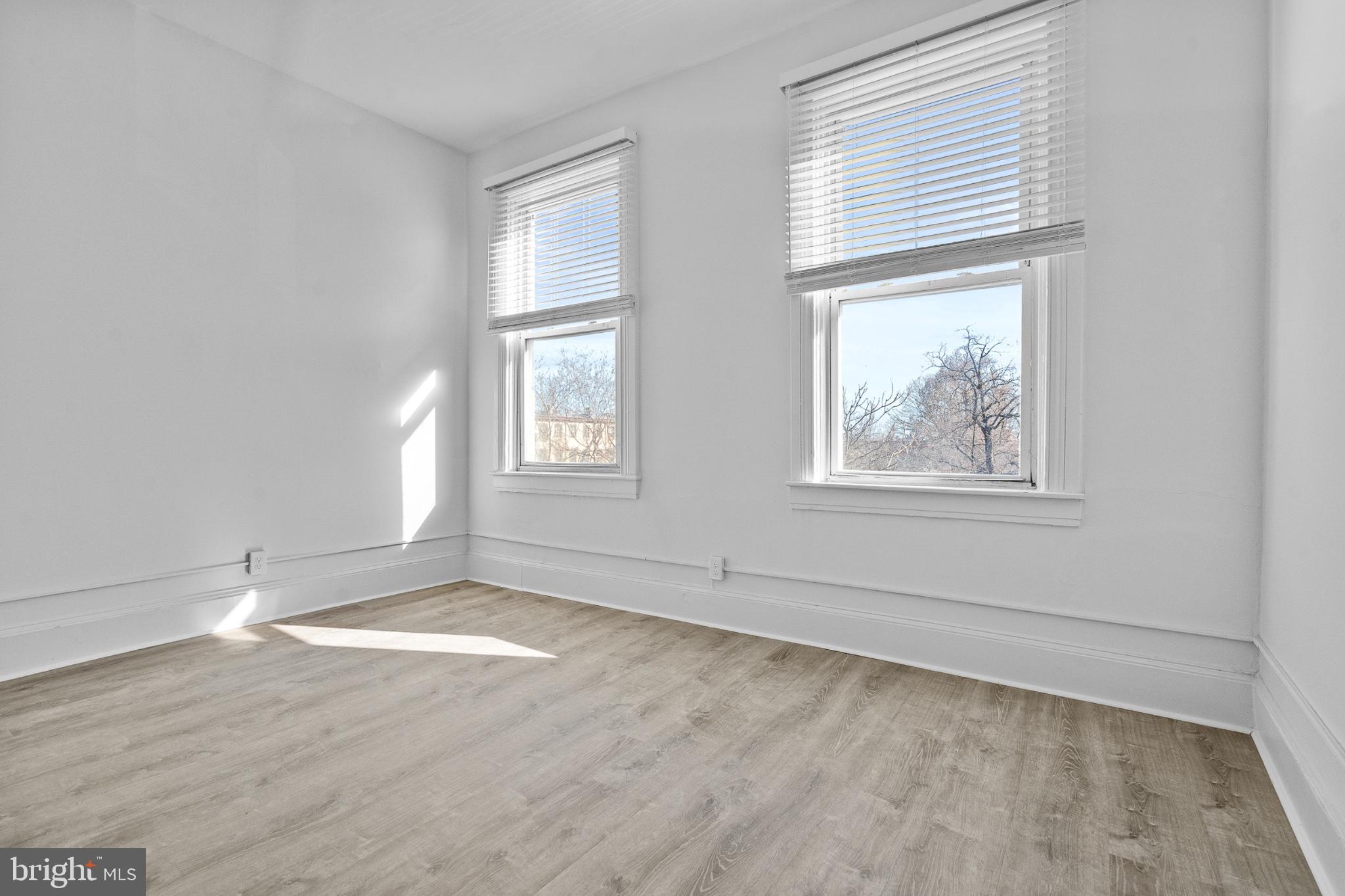 1308 West Lexington Street, Unit 3F Baltimore, MD 21223 - Photo 5 of 14 an empty room with wooden floor and windows