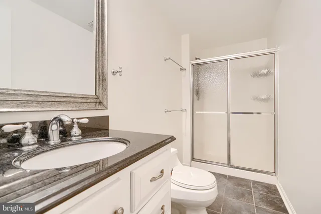 a bathroom with a sink toilet double vanity and shower