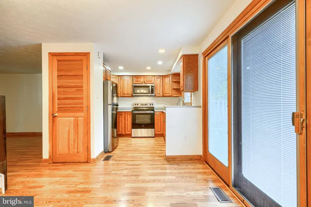 a view of a kitchen with wooden floor and a refrigerator