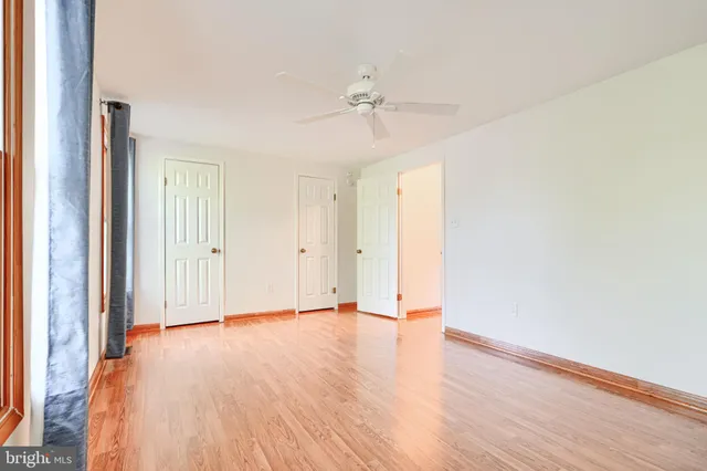 a view of an empty room with wooden floor
