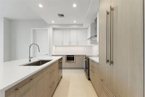 a kitchen with white cabinets and stainless steel appliances