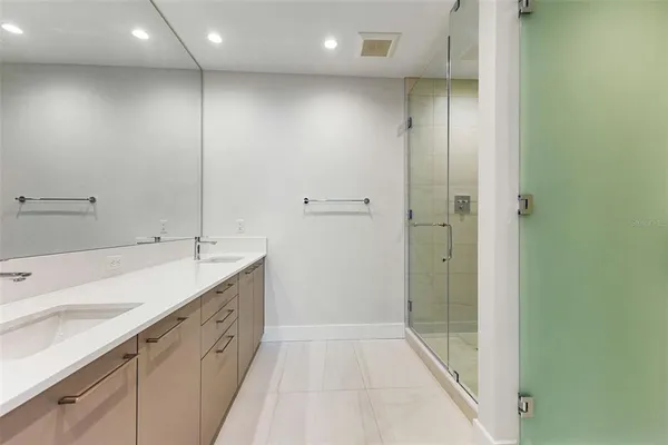 a spacious bathroom with a shower sink and mirror
