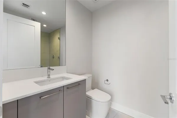 a bathroom with a sink a toilet and mirror